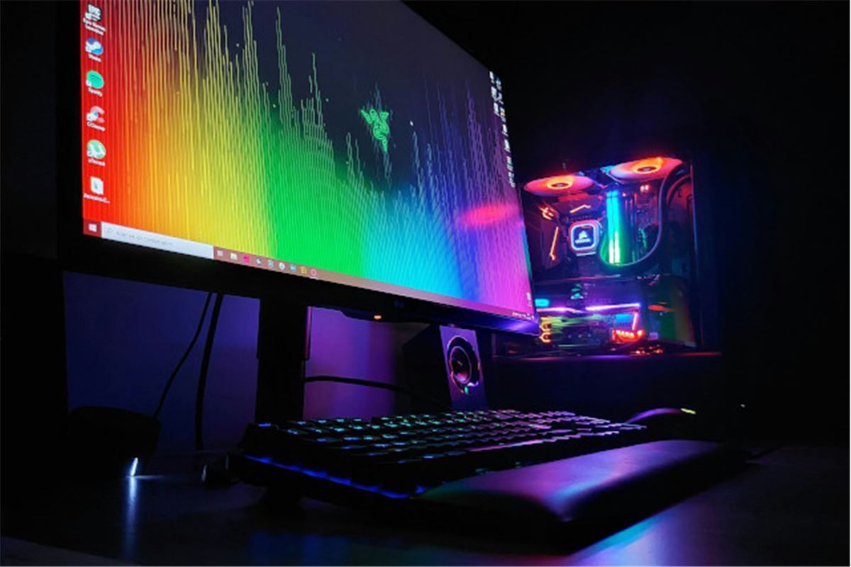 PC gamer de bureau avec écran, clavier et souris sur un bureau en bois